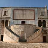 Dall�arco si snoda un viale lungo un centinaio di metri che porta ai piedi del prezioso edificio. La facciata principale in pietra chiara si presenta semplice e compatta: l'unica punta di colore � un riquadro rettangolare rosso che compare in alto e che probabilmente in origine ospitava un affresco